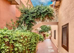 a walkway between two buildings with plants at Residence a Golfo di Marinella a 450 mt dal mare in Marinella