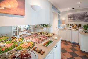 una cocina con muchos platos de comida en una barra en Hotel zur Post - Economy Rooms, en Garrel