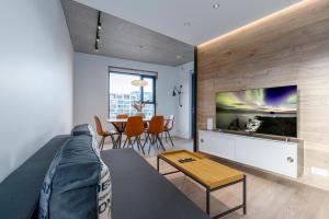 a living room with a couch and a tv and a table at Blue Viking Apartments Reykjavik in Reykjavík +12 photos