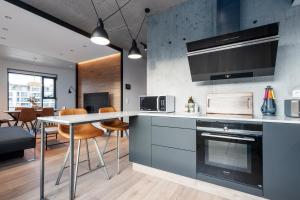a kitchen with a counter and a table with chairs at Blue Viking Apartments Reykjavik in Reykjavík