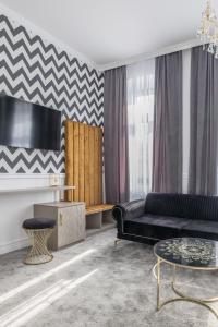 ein Wohnzimmer mit einem schwarzen Sofa und einem Tisch in der Unterkunft Hotel Vila Central Boutique Satu Mare in Satu Mare