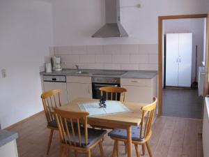 a kitchen with a wooden table with chairs and a sink at Holiday Home Debacher in Kappel-Grafenhausen +2 photos