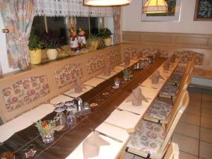 a long dining room with a long table and chairs at Landgasthof Zum Schloss in Birgland