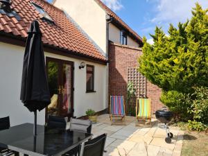 a patio with a black table and chairs at Rural escape with countryside views & Log burner in Coddenham