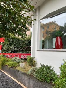 ein Fenster eines Gebäudes mit einer roten Vase darin in der Unterkunft Hotel del Sole-Aversa in Aversa