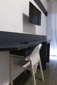 un bureau noir avec une chaise blanche et une télévision dans l'établissement Hotel del Sole-Aversa, à Aversa