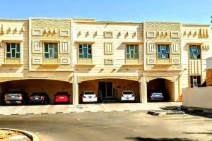 um grande edifício com carros estacionados em frente em Full Apartment in Central Al Ain (All Amenities) em Al Ain