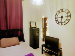 a bedroom with a bed and a clock on the wall at Full Apartment in Central Al Ain (All Amenities) in Al Ain