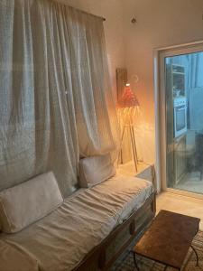 Cama en habitación con ventana y lámpara en Studio Marsa, en La Marsa