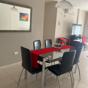 comedor con mesa y sillas con mantel rojo en Torre Reggia II en Córdoba