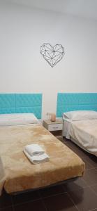 1 dormitorio con 2 camas y un corazón en la pared en Apartamento14 Ruidera AguaPlacer, en Ruidera