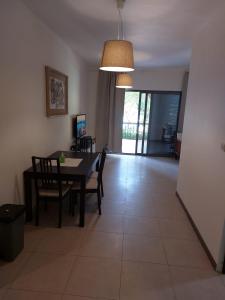 a dining room and living room with a table and chairs at Ground floor apartment by circular pool in Talabay (sweet coffee apartment) in Aqaba