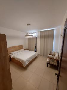 una camera con un letto e una sedia di Ground floor apartment by circular pool in Talabay (sweet coffee apartment) ad Aqaba