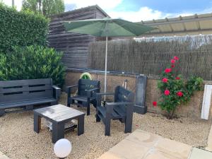 a patio with two chairs and a table and an umbrella at La Costonnerie in Leigné-sur-Usseau