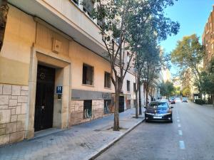 un coche aparcado en una calle al lado de un edificio en Hostal Arrate en Madrid