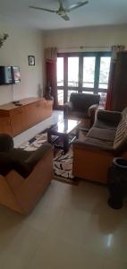 a living room with couches and a coffee table at Global Mansion Service Apartment in Bangalore