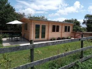 a tiny house in a field with a fence at Cosy cabin for two in Truro