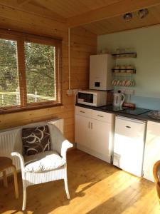 a kitchen with a white chair and a microwave at Cosy cabin for two in Truro