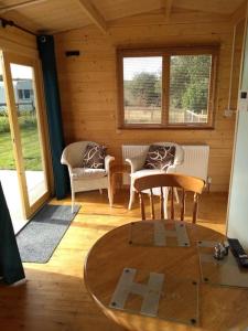 a living room with a table and chairs in a cabin at Cosy cabin for two in Truro