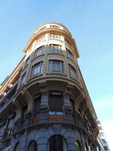 un edificio alto con balcón en la parte superior en Hotel Trueba, en San Sebastián