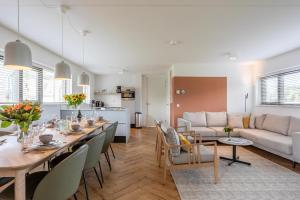 a dining room and living room with a table and a couch at Duyndomein Noordwijk in Noordwijk