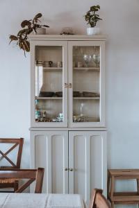 a white cabinet with glass doors in a dining room at Livas Residence in Megálon Khoríon