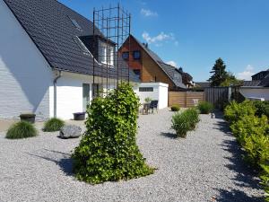 una casa con un arbusto en medio de un patio en dat witte hus 1, en Büsum