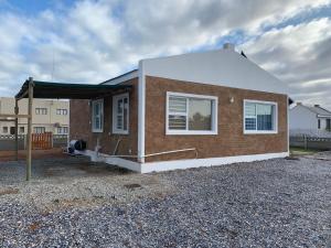 ein kleines Backsteinhaus mit weißem Dach in der Unterkunft Strandfontein holiday house in Strandfontein