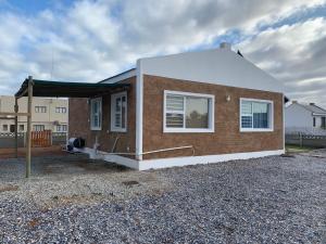 a small brick house with a white roof at Strandfontein holiday house in Strandfontein