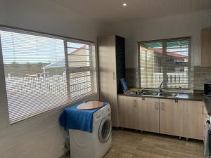 a kitchen with a washing machine and a sink at Strandfontein holiday house in Strandfontein +6 photos