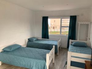 1 Schlafzimmer mit 2 Betten und einem Fenster in der Unterkunft Strandfontein holiday house in Strandfontein