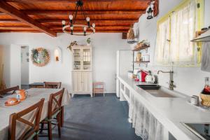 a kitchen with a long counter and a table with chairs at Livas Residence in Megálon Khoríon