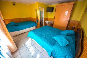 1 dormitorio con 2 camas y TV. en Hotel Montecarlo, en Caldera