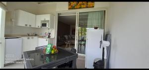 a kitchen with a refrigerator and a table in it at Grand studio les pieds dans l'eau, centre ville in Le Gosier
