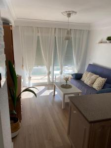 un soggiorno con divano blu e tavolo di A&C Algarrobo costa - Malaga a Algarrobo-Costa