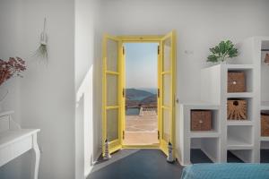 a yellow door in a white room with a view at Livas Residence in Megálon Khoríon