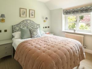 Salperton的住宿－Grove Cottage，一间卧室设有一张大床和两个窗户。