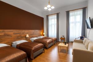 a hotel room with three beds and a couch at Hotel Museum in Prague