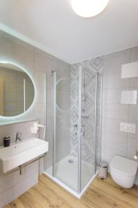 La salle de bains est pourvue d'une douche, d'un lavabo et de toilettes. dans l'établissement Hotel TwentyFour Living, à Bad Urach
