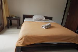 a bed with a suitcase sitting on top of it at Baik Baik Homestay in Uluwatu