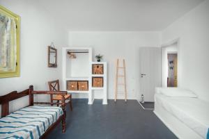 a living room with a couch and a white wall at Livas Residence in Megálon Khoríon