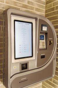 an atm machine with a tv on a wall at Hotel TwentyFour Living in Bad Urach