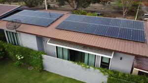 een huis met zonnepanelen op het dak bij PoolVilla Breeze Valley in Cha Am