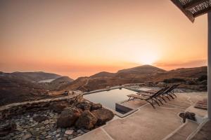 a swimming pool with a sunset in the background at Livas Residence in Megálon Khoríon