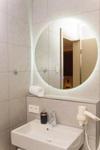 W łazience znajduje się biała umywalka i lustro. w obiekcie Hotel TwentyFour Living w mieście Bad Urach