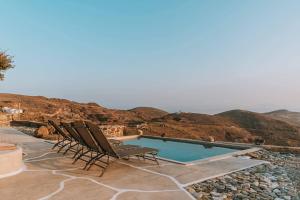a group of chairs sitting next to a swimming pool at Livas Residence in Megálon Khoríon