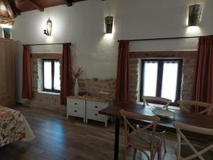 a living room with a wooden table and chairs at Apartamentos Turísticos El AOVE in Baeza