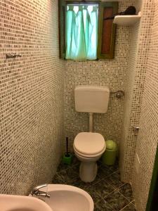 a small bathroom with a toilet and a window at Holiday Home Case Blu in Lipari