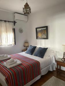 um quarto com uma cama grande e um cobertor colorido em La Casita del Corralon em Granada