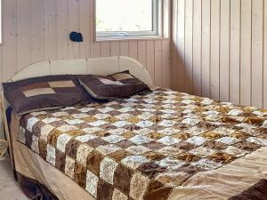 a bed in a room with a quilt on it at 5 person holiday home in V ggerl se in Marielyst